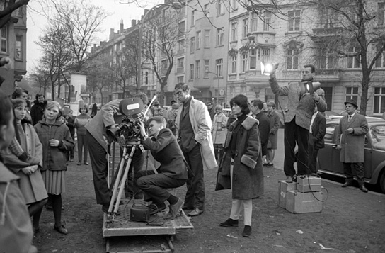 Jost Vacano (an der Kamera), Peter Schamoni (dahinter) bei den Dreharbeiten zu "Schonzeit für Füchse" (1965/66) am Fürstenplatz in Düsseldorf Schonzeit für Füchse