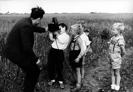 Kameramann Hans-Eberhard Leupold mit den Kindern in Golzow - Jochen T. (an der Kamera), Jürgen W. (rechts), 1962 ("Lebensläufe. Die Geschichte der Kinder von Golzow in einzelnen Portraits", 1981); Quelle: BArch, FMD