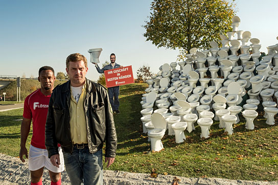 Castro Dokyi Affum, Sebastian Bezzel (v.l.n.r.) in "Leberkäsjunkie" (2019); Quelle: Constantin Film Verleih, DFF, © 2019 Constantin Film Verleih GmbH, Bernd Schuller
