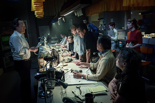 Peter Sarsgaard (links), Zinedine Soualem (am Tisch 3.v.h.), John Magaro (am Tisch 4.v.h.), Ben Chaplin (am Tisch 3.v.v.), Marcus Rutherford, Georgina Rich, Leonie Benesch (rechts stehend, v.h.n.v.) in "September 5" (2024)