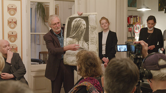 Gunar und Nora Barthel (2.+3.v.l.) in ihrer Berliner Galerie für nonkonkforme Kunst - mit dem ersten Clara-Mosch-Plakat in "Go Clara Go: die Kunst des kreativen Widerstands" (2025)