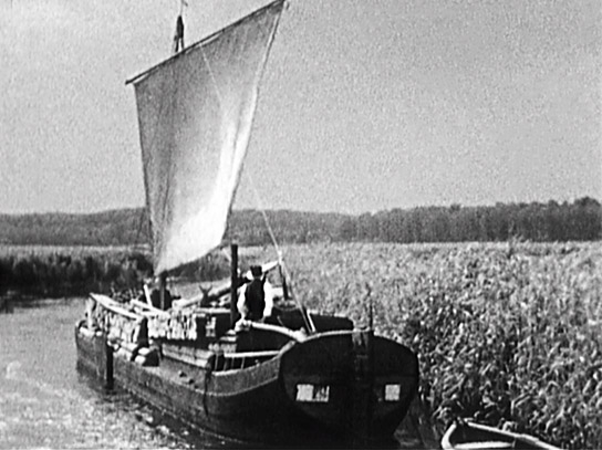 Ein Holzkahn mit Holz aus Masuren auf Talfahrt Richtung Elbing auf dem Oberländischen Kanal, 1936. Aus dem Film 'Schiffe fahren über Berge' der Königsberger Filmarbeitsgemeinschaft im Bund deutscher Filmamateure. ("Ostpreußen - Entschwundene Welt", 2025)