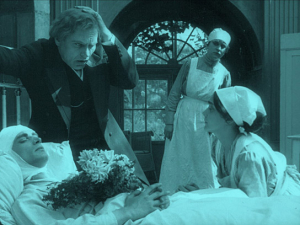 Screenshot mit Conrad Veidt (liegend), Eduard von Winterstein (2.v.l.), Sybil Morel (vorne rechts) aus "Opium" (1919); Quelle: Filmmuseum München