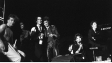 FM Einheit, Mona Mur, Nikko Weidemann, Blixa Bargeld, Marianne Rosenberg, Rio Reiser (v.l.n.r.) bei einem Konzert in der Schaubühne am Lehniner Platz, Berlin am 26. Oktober 1984 ("Mona Mur im Gespräch", 2024)